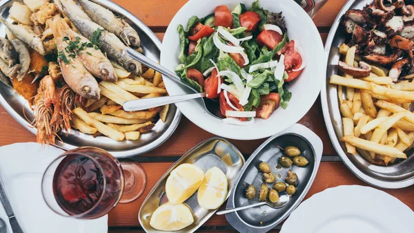 Kıbrıs balığı ve deniz mahsulleri mezesi, zeytin, limon ve Yunan salatası.