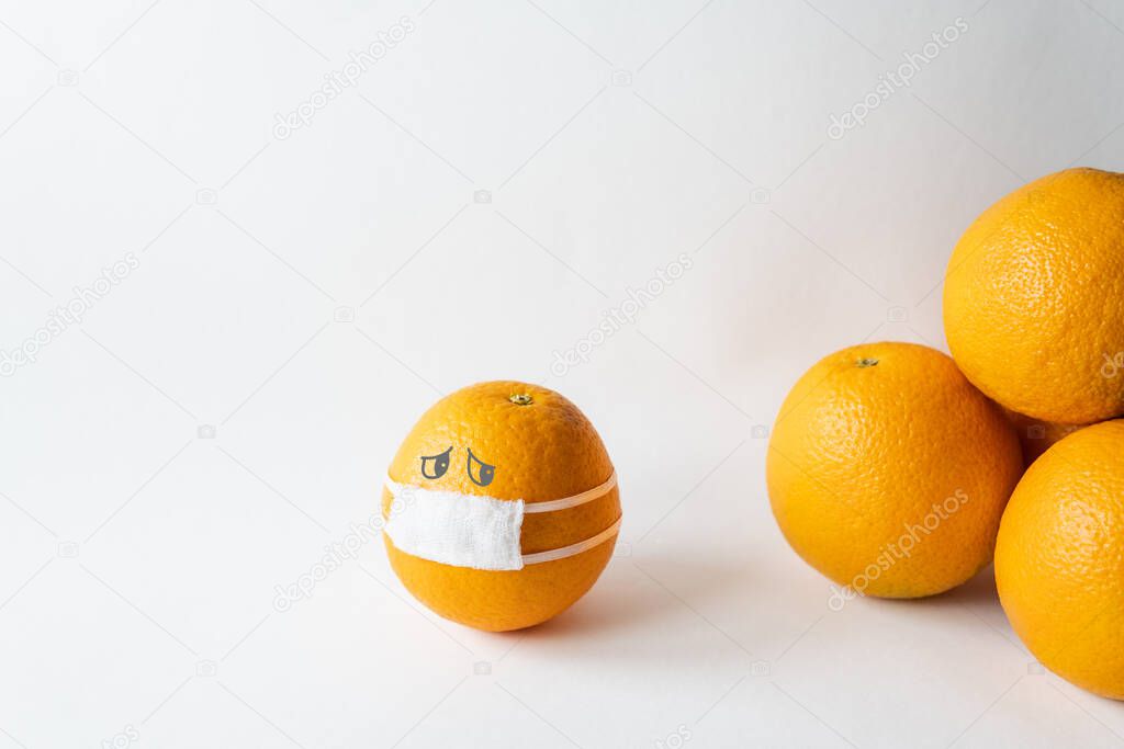 Orange wearing medical mask isolated from the crowd. Conceptual image of social distancing.