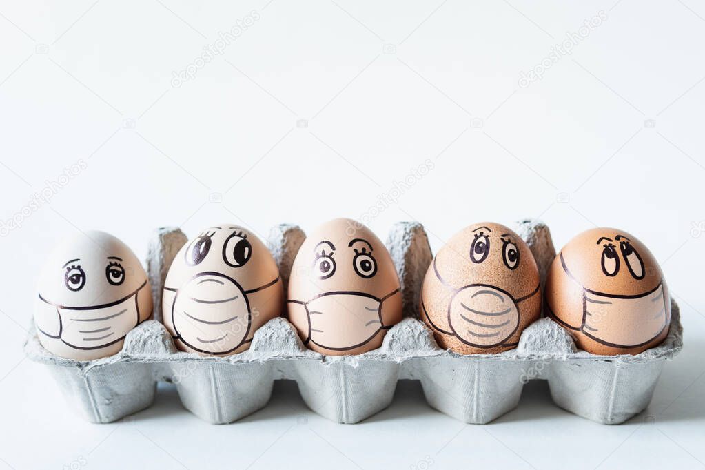 Diverse chicken eggs with doodle faces wearing medical masks with white background. Conceptual image of pollution and epidemy