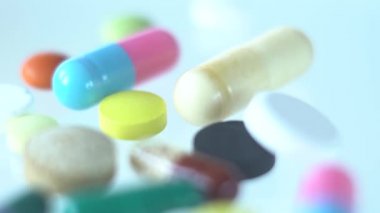 Beyaz arka planda çeşitli haplar ve uyuşturucular üzerinde Dolly hareketi