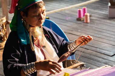 Inle, Myanmar - Mart 2019: Kayan Lahwi kabilesi uzun boyunlu kadın Inle gölü üzerinde bir turist dükkanında tezgah arkasında oturur