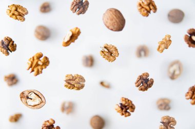 Beyaz arka planda uçan kabuklu cevizler, havada kalma efekti.