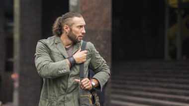 Sokakta çanta taşıyan genç bir adamın portresi, yaşam tarzı.