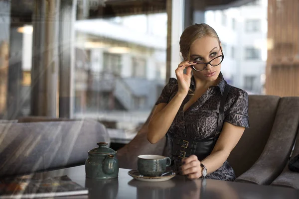 Genç iş kadını kahve içiyor.