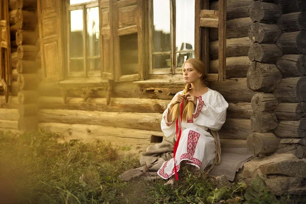 Russian woman with a cat near old wooden house in a village — Stock Photo, Image