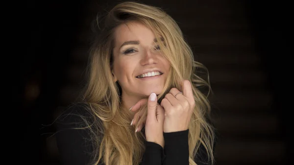 Close-up portrait of smiling young woman with curly blond hair — Stock Photo, Image