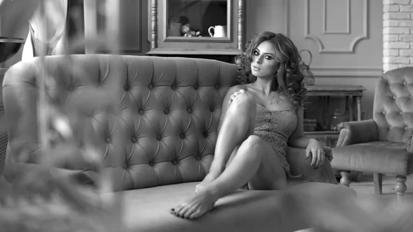 Jeune femme sexy posant sur le canapé dans un intérieur vintage — Photo
