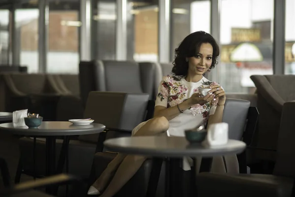 Bella donna dai capelli scuri seduta al ristorante. Guardando altrove bere caffè — Foto Stock