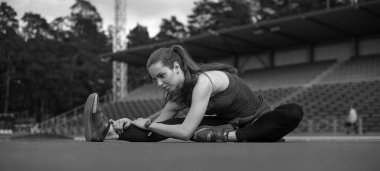 Spor. Koşucu koşu parkuru germe. Stadyumun arka planda.