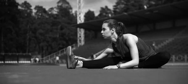 Spor. Koşucu koşu parkuru germe. Stadyumun arka planda. — Stok fotoğraf