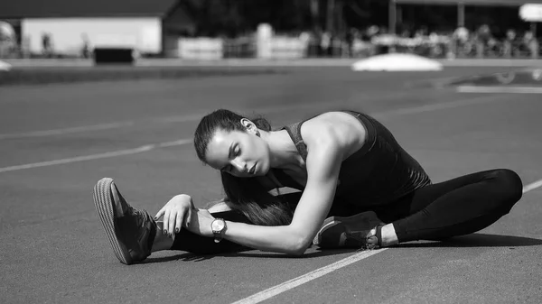 Spor. Koşucu koşu parkuru germe. Stadyumun arka planda. — Stok fotoğraf