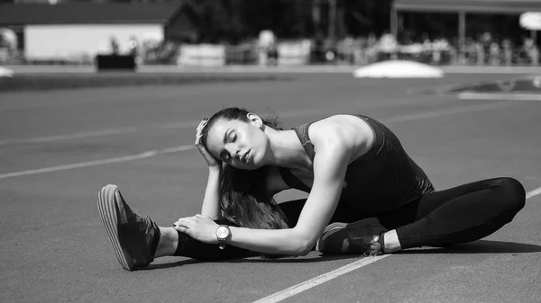 Spor. Koşucu koşu parkuru germe. Stadyumun arka planda. — Stok fotoğraf