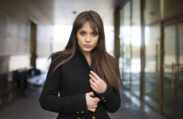 Молодая красивая модель. Динамично молодая девушка идет по улице. Волосы трепещут на ветру
.