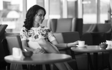 Genç kadın kapalı kentsel kafede oturan onun smartphone içme kahve ve kullanım. Cafe city yaşam tarzı. Güzel kız rahat portresi. Siyah ve beyaz