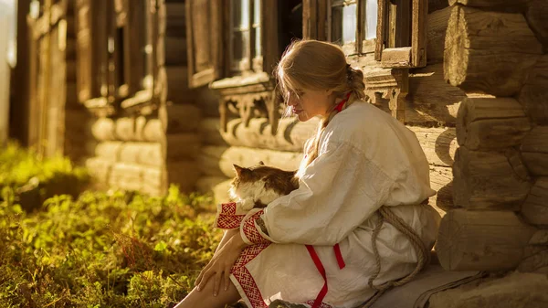 Rus kadın ile bir kedi yakın bir köyde eski ahşap ev