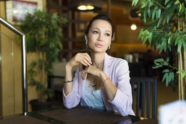 Beautiful woman dreaming about something while sitting in modern cafe bar, young charming female freelancer thinking about new ideas — Stock Photo, Image