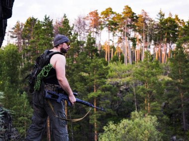 Rus nişancı dağda, savaş kavramı içinde askeri ormanda düşman vurmak için hazırlanıyor