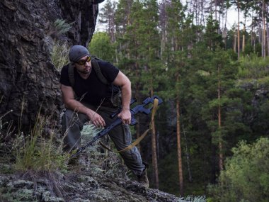 Rus nişancı dağda, savaş kavramı içinde askeri ormanda düşman vurmak için hazırlanıyor