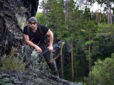 Rus nişancı dağda, savaş kavramı içinde askeri ormanda düşman vurmak için hazırlanıyor