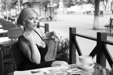 Yerel tatlı tatlılar şehir çevresindeki uzun bir yürüyüşten sonra modern kafede otururken tadını genç neşeli kadın turist. Retro Hollywood tarzı.