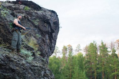 Bir keskin nişancı tüfeğiyle ormandaki portresi