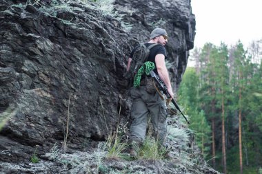 Bir keskin nişancı tüfeğiyle ormandaki portresi