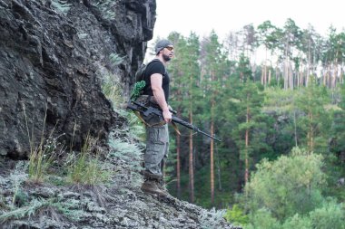Bir keskin nişancı tüfeğiyle ormandaki portresi