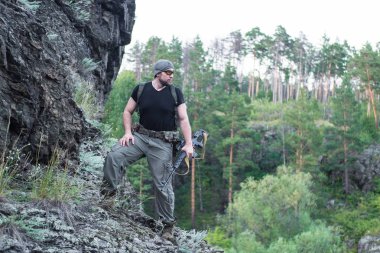 Bir keskin nişancı tüfeğiyle ormandaki portresi