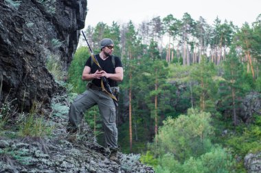 Bir keskin nişancı tüfeğiyle ormandaki portresi