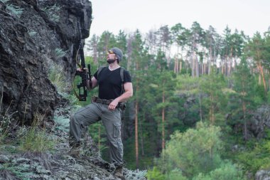 Bir keskin nişancı tüfeğiyle ormandaki portresi