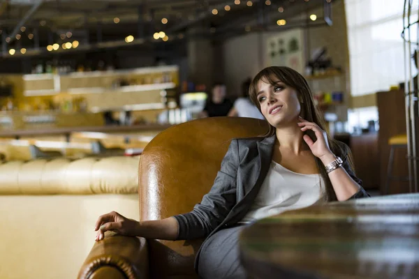 Belle jeune femme brune dans un café. L'heure d'été. Lumière du jour. Femme d'affaires. Mode de vie . — Photo