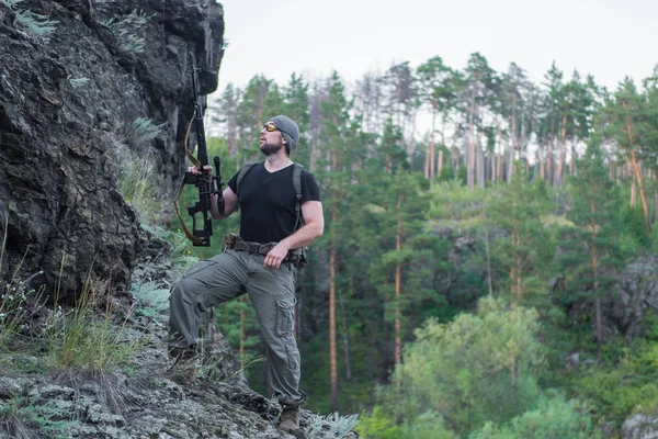 Bir keskin nişancı tüfeğiyle ormandaki portresi