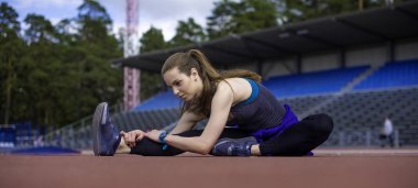Atletik kadın yolda koşu önce kasları germe