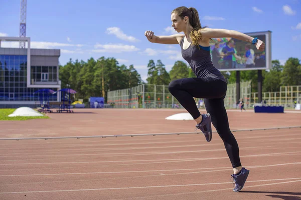 Mujer atlética corriendo en pista — Foto de Stock