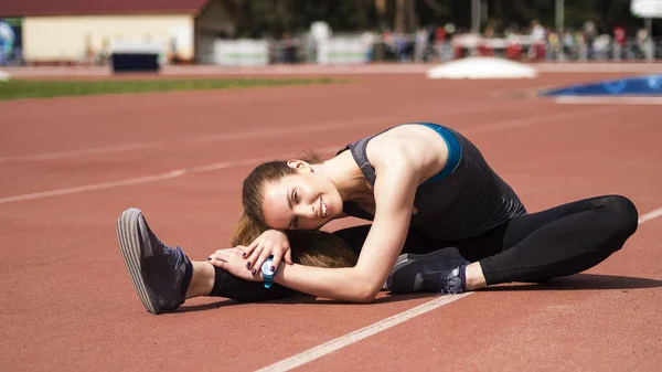 Atletik kadın yolda koşu önce kasları germe — Stok fotoğraf