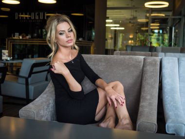 Genç kadın sonraki bir defterde bir kafe ve yazma pencere pervazına oturuyor