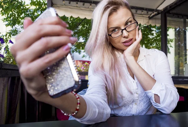 Hermosa mujer de negocios en gafas tomando una selfie en un café — Foto de Stock