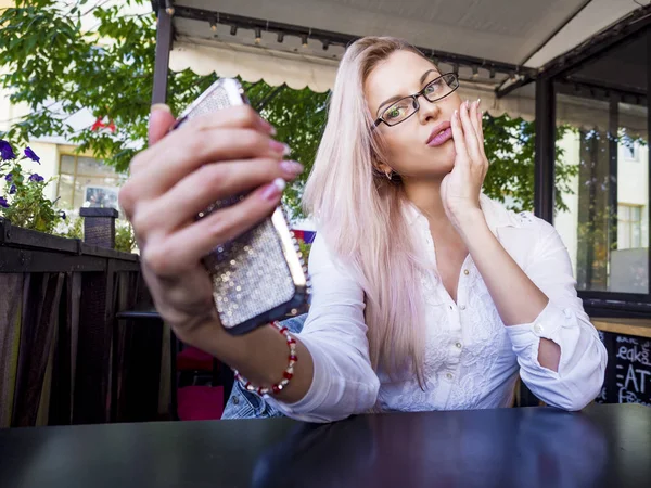 Hermosa mujer de negocios en gafas tomando una selfie en un café — Foto de Stock