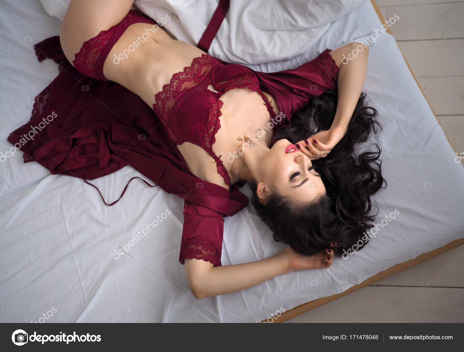 Beautiful and thoughtful woman lying on the bed in red lingerie. Sensual  awakening. Stock Photo by ©dmitryvbel.rambler.ru 171478048