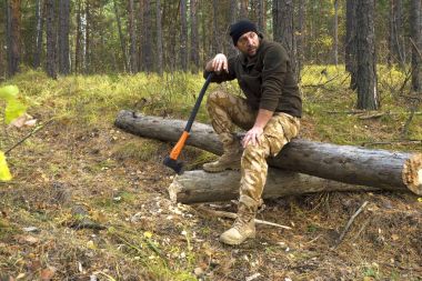 Ormanda oturan oduncu işçi. Sabit işten sonra dinlenme.