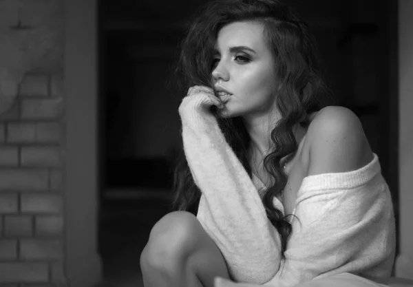 Sensual sad woman sits next the window on the bed. Black and white picture. — Stock Photo, Image