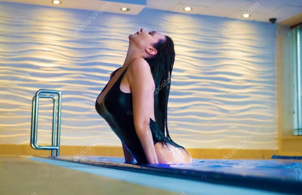 Verführerische blonde Frau mit langen nassen Haaren, gekleidet in