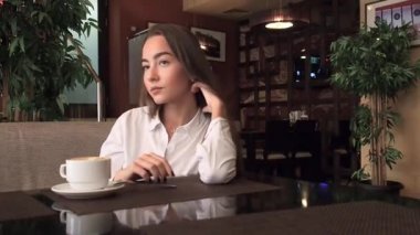 Şehvetli genç iş kadını grinkig çay bir kafede. Seksi gülümseyen ve kadınlar