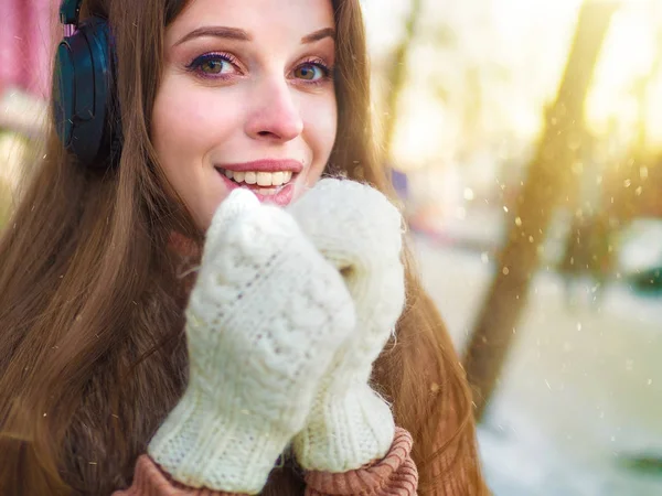 Jolie femme heureuse dans les écouteurs écoutant la nusic et vous souriant — Photo