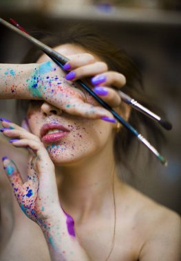 eller bir kadın sanatçı portresi yüzünde boyalar bir damla ile ah. Fırçalar elinde