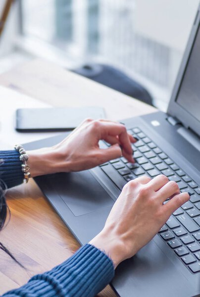 Woman working on computer at wooden desk