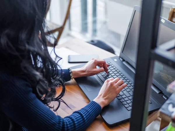 Μια κοπέλα που εργάζεται στο φορητό υπολογιστή σε ένα καφενείο, γυναίκας δάχτυλα δακτυλογράφηση στο πληκτρολόγιο. — Φωτογραφία Αρχείου