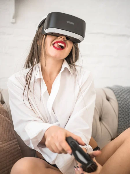 technology, augmented reality, entertainment and people concept - happy young woman with virtual headset or 3d glasses playing game at home