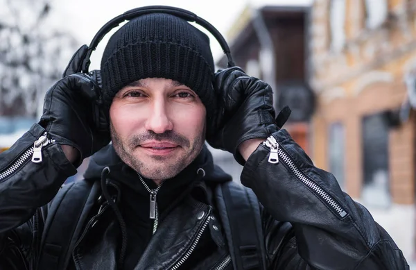 Kış caddede yürüyüş ve kulaklık ile müzik dinlemek gülümseyen adam — Stok fotoğraf