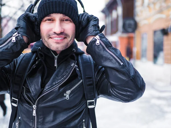 Kış sokak walkin ve kulaklık ile müzik dinlemek gülümseyen adam — Stok fotoğraf